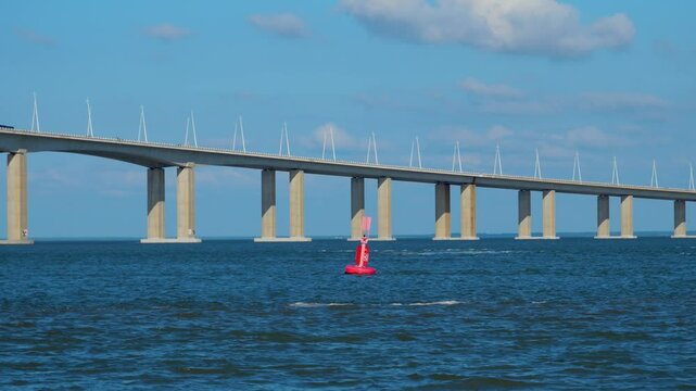 Vasco da Gama Bridge floats above the river, forming an abstract architectural background. Clean horizontal lines, deep blue water, and minimalist design blend with sky and colorful buoys.