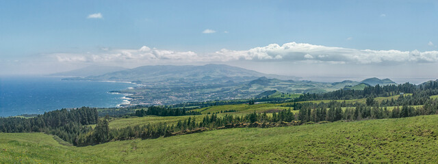 Fototapeta premium Coastal landscape with green hills and distant mountains, Miradouro do Salto do Cavalo, Sao Miguel, Azores, Portugal