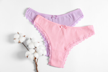 Women's underwear. Beautiful panties and cotton flowers on white background, flat lay