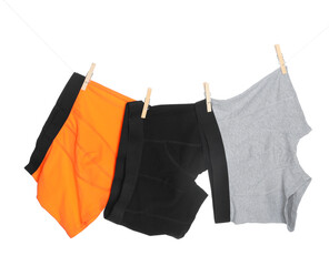 Comfortable men's underwear on clothes line against white background