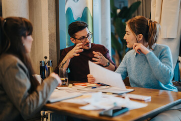 Three colleagues engage in an intense brainstorming session, discussing ideas during a planning...