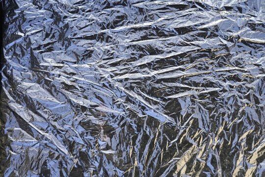 Wrinkled texture of plastic film with shiny effect. Background. Texture. Close-up.