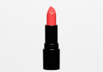 Fototapeta premium A single lipstick tube with a bright coral color against a plain white studio background image view