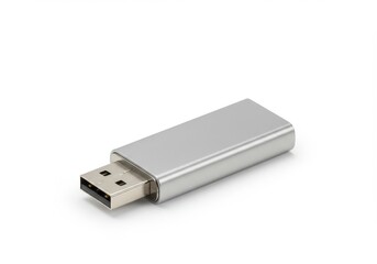 Close up of a silver usb drive lying on a white surface in a studio with soft lighting conditions