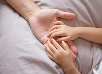 Asian baby hands on fathers hand