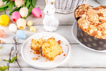 Italian Easter Colomba Cake, Colomba di Pasqua, sweet sugared dove-shaped sponge cake with glazed nuts and fruits, festive fruit- stuffed bread on white Easter holiday decorated table copy space