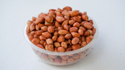 Uncooked peeled peanuts in wooden placemats  on desk