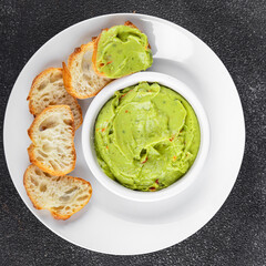 Guacamole dip avocado sauce cold appetizer vegetable dish organic product fresh tasty gourmet food background on the table rustic food top view copy space 