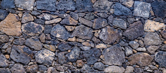 Beschreibung: Panoramaaufnahme einer Natursteinmauer aus Lavasteinen auf den Azoren. Die Mauer zeigt die beeindruckende Geologie der Region und eignet sich ideal als Hintergrundtextur
