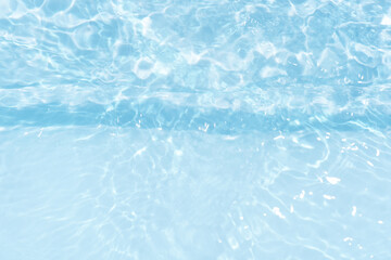 Blue water with ripples on the surface. Defocus blurred transparent blue colored clear calm water surface texture with splashes and bubbles. Water waves with shining pattern texture background.