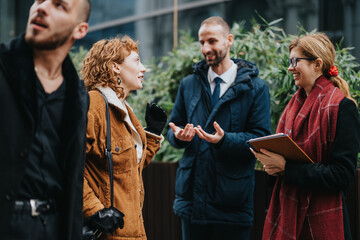 Four individuals gather outside near greenery, dressed formally, engaging in an animated...