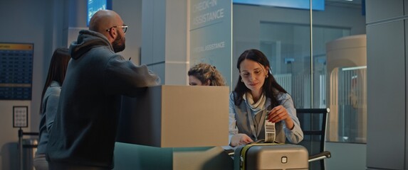 Airport Counter: Female Airline Check-in Attendant Putting Baggage Tag Barcode on Suitcase for...