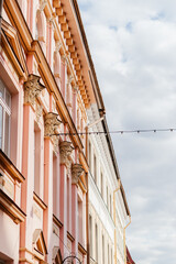 A charming European street lined with pastel-colored historic buildings, ornate architectural details, and a nostalgic atmosphere under a soft daylight sky