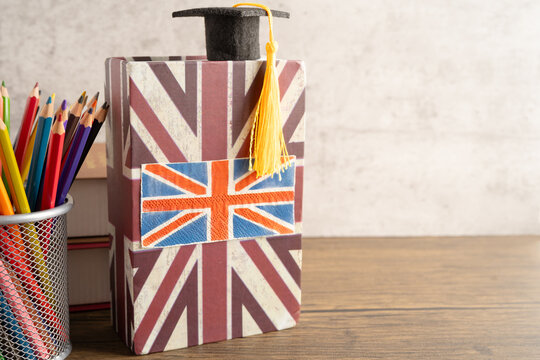 UK flag with graduate hat on english language book.