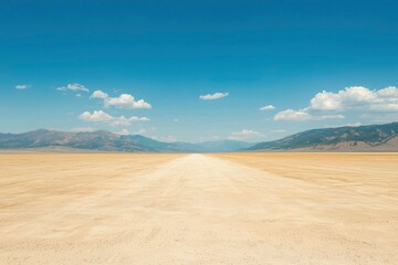 Obraz premium Desert Road Leads to Distant Mountains under Bright Sky with Scattered Clouds