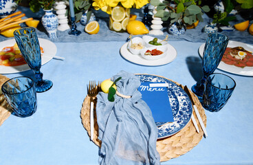 Elegant Table Setting with Blue Glassware and Floral Decor for a Special Occasion