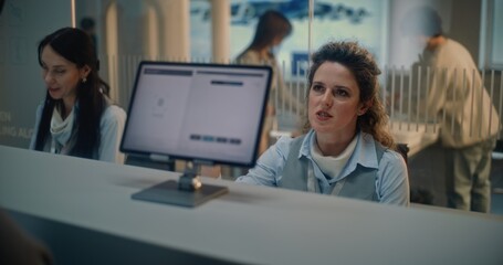 Naklejka premium Airport Check-in Counter: Female Airline Agent Checks Passenger Biometric Data for Flight. Man Puts Finger on Touch Screen for Identification by Scanning Fingerprint. International Airport Terminal.