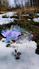 Vertical. garbage in the forest in the form of empty plastic bottles after winter, in spring....