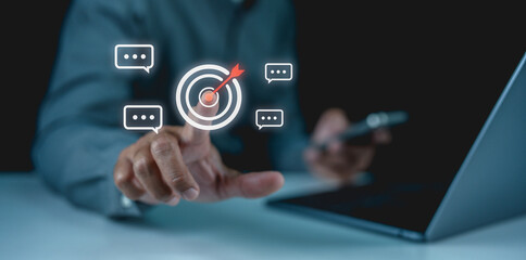 A businessman interacts with digital chat icons on a screen, emphasizing communication and technology in a modern workspace.