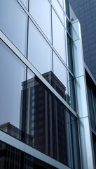 Obraz premium tall building is reflected in the windows of another building
