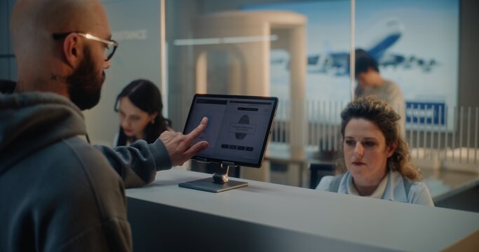 Airport Check-in Counter: Female Airline Worker Checking Tourist Personal ID Data for Flight. Man Putting Finger on Touch Screen for Biometric Fingerprint Scanning. International Airport Terminal.