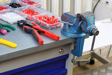 Metal vice on the electrician's table with metal coating. 