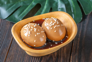 Two ajitsuke tamago ramen eggs marinated with soy sauce and sesame seeds