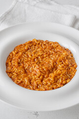 Creamy tomato risotto on clean white plate