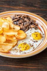 Golden potato dippers, fried eggs, and mushrooms on rustic textured table setting