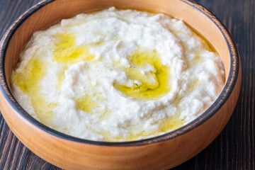 Creamy baba ghanoush in wooden bowl with chili and olive oil
