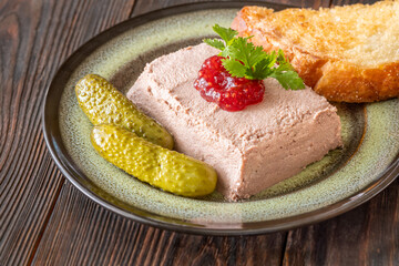 Goose liver pate served with toasted bread, cranberry jam, and pickles