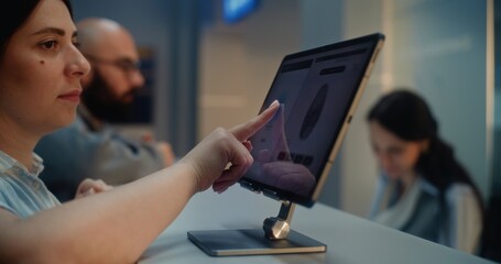 Passengers at Airport Check-in Counter: Side View of Woman Putting Finger on Touch Screen for...