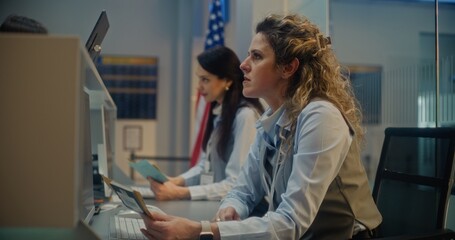 Airport Check-in Counter: Female Airline Agents Checking Documents and Airplane Tickets of...