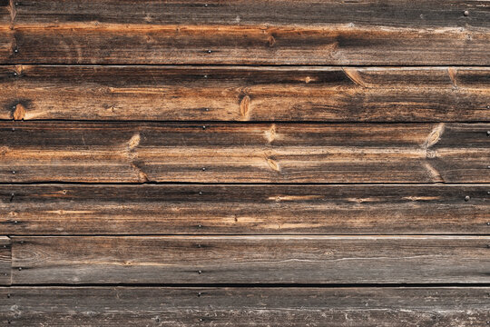 Close-up of old wooden wall texture with visible grain and rustic tones. Wooden surface, natural material, vernacular architecture, eco-lifestyle philosophy