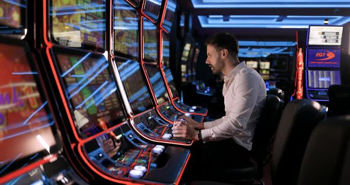 Man Playing Slot Machine in Casino: A Gambler's Rollercoaster of Emotions