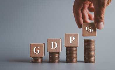 Hand picks up wooden block with GDP percent symbol, Economic prosperity, Profits and business growth