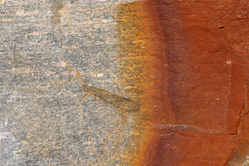  Background of rock surface with natural gray and orange patterns and textures created by rust on...