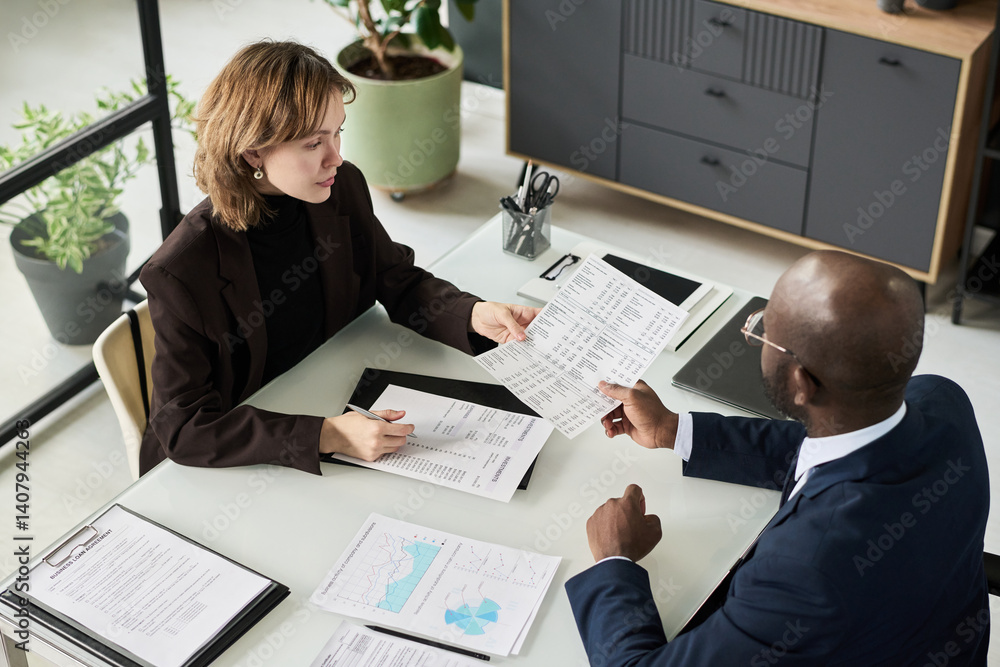 Aufkleber high angle view of colleagues analyzing financial documents together at meeting