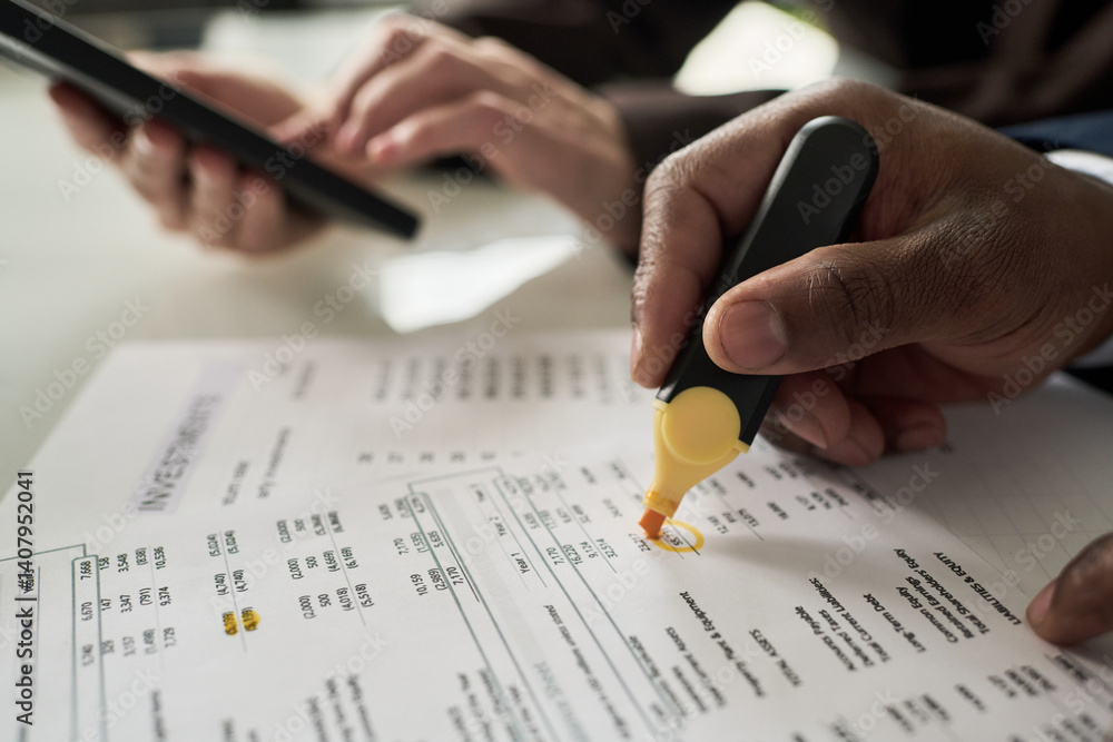 Poster Close-up of businessman noting data on document with marker while his colleague using calculator