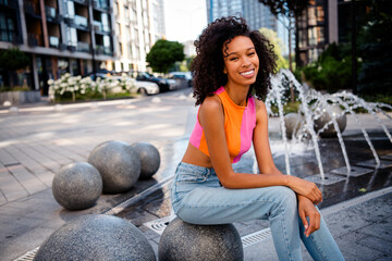 Photo of pretty young woman sitting relax wear colorful clothes walk outside urban enjoy fountain...