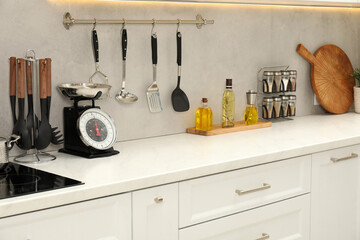 Retro mechanical kitchen scale, other utensils and spices on white marble table indoors