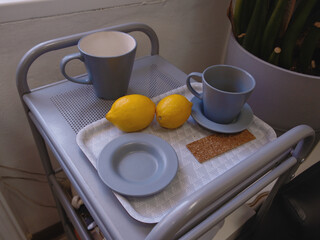 ceramic blue mugs and lemons on serving table, in office