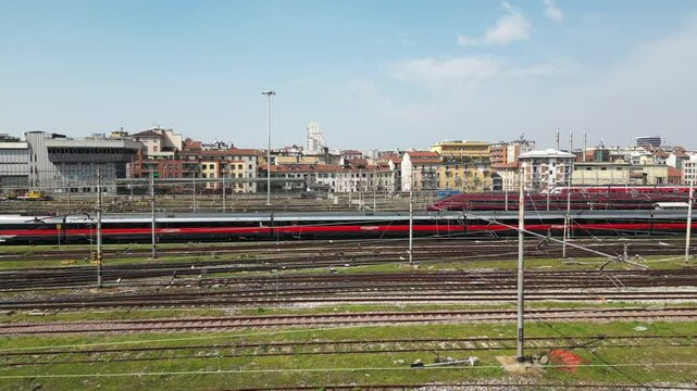 Europe,Italy, Milan 04,27,2025 drone view of Centrale train station railway with skyline in downtown - travel with Frecciarossa and Italo high speed trains to Bologna, Florence, Rome and Naples 
