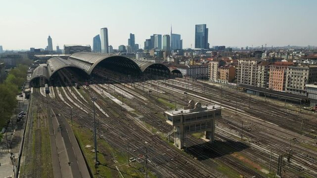 Europe,Italy, Milan 04,27,2025 drone view of Centrale train station railway with skyline in downtown - travel with Frecciarossa and Italo high speed trains to Bologna, Florence, Rome and Naples 