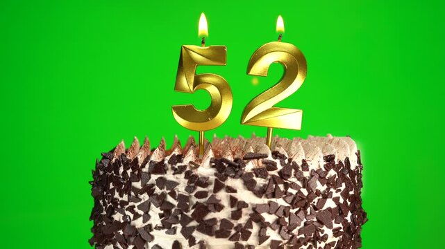 Burning candles number 52 on birthday cake against chroma key background. Fifty-second birthday. Birthday celebration