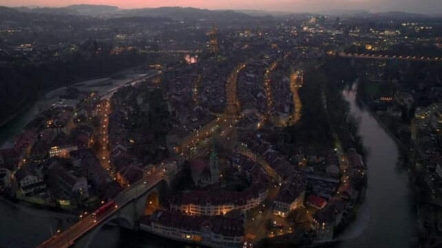 Illuminated City of Bern in Switzerland from above in Night Twilight - the Capital city Evening view. Aerial Drone shot.