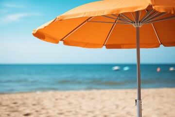 close up orange beach sun umbrella stands on beach with blue sea or ocean on blurred background, beach holiday advertising image with copy space
