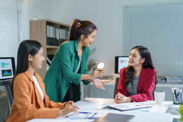 Three businesswomen engaging in a lively discussion about a project during a meeting in a stylish, modern office setting