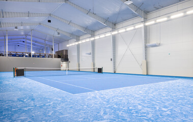 Spacious Indoor Sports Facility with Blue Flooring and a Tennis Court