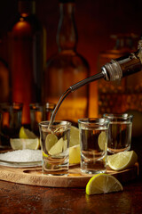 Gold tequila with salt and lime slices.